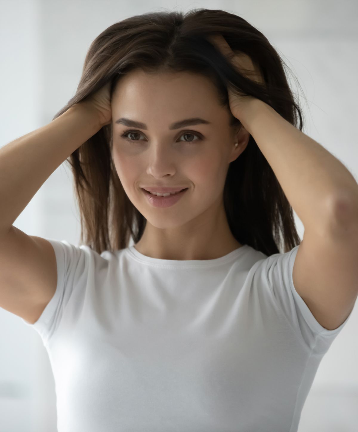 Woman smiling and touching her hair.